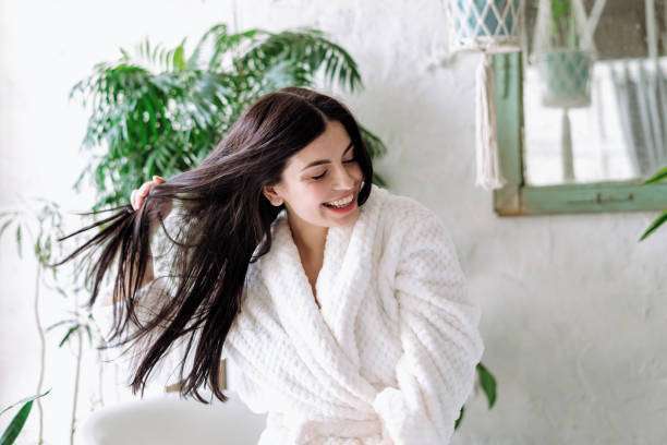 Smiling woman shaking head with floating hair oil
