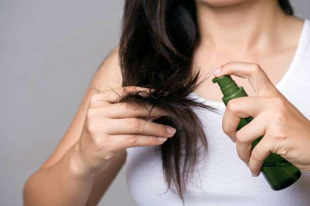 housewife in pajamas with long brunette wavy hair holding hair oil