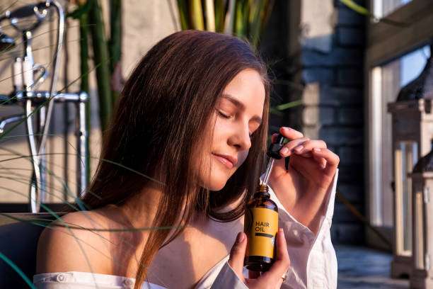 Woman showing healthy, shiny hair, likely benefiting from a nourishing hair oil treatment.