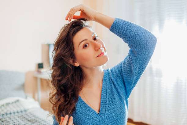 Woman showing healthy, shiny hair, likely benefiting from nourishing hair oil treatment.