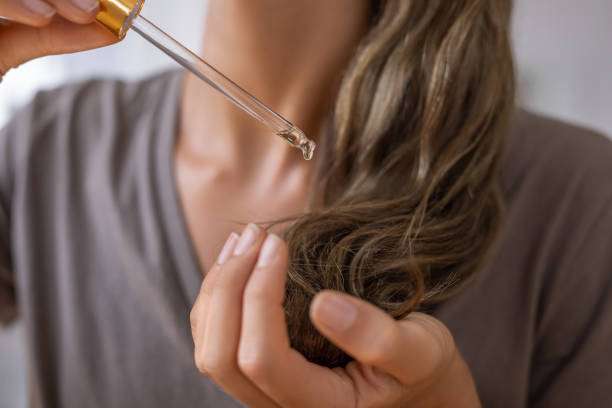Woman showing healthy, shiny hair, likely benefiting from a nourishing hair oil treatment.