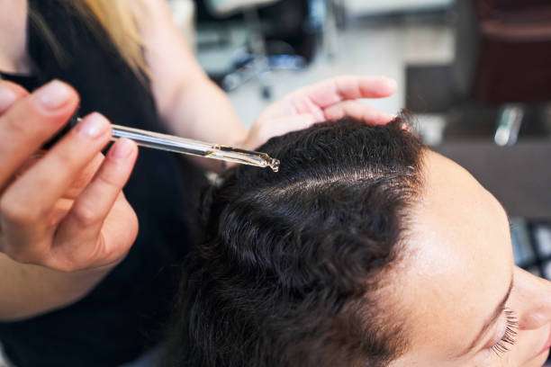 Scalp treatment with hair oil to promote healthy hair growth.