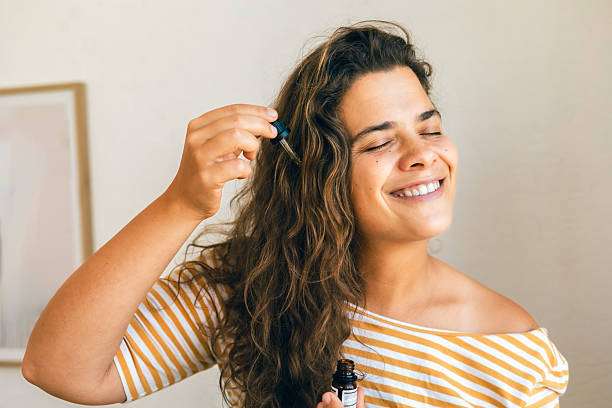 Woman showing healthy, shiny hair, likely benefiting from a nourishing hair oil treatment.