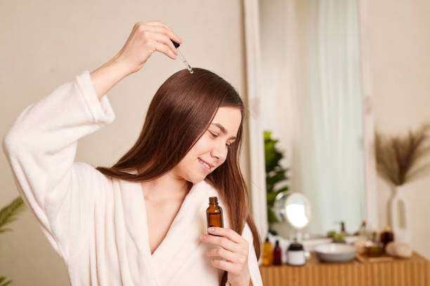 Woman showing healthy, shiny hair, likely benefiting from a nourishing hair oil treatment.