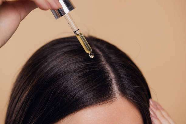 Close-up of hair oil dropper on scalp